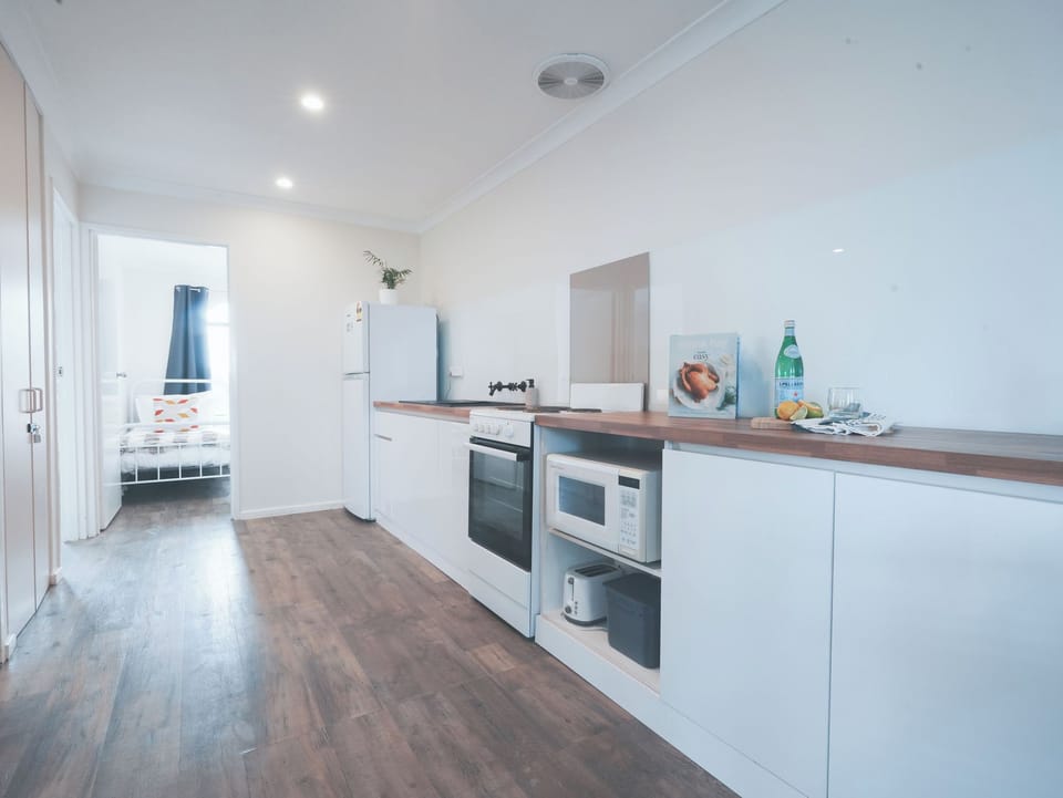 Kitchen with the essentials for your stay. Stove, oven, microwave, full fridge, cooking and crockery essentials.