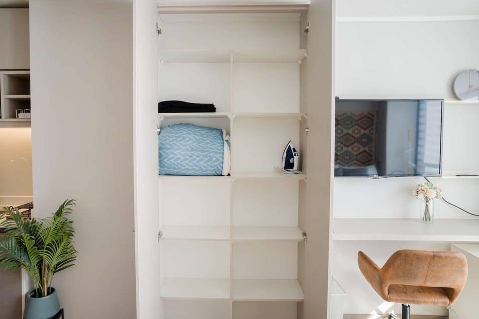Bright and functional studio with ample storage, a sleek workspace, and modern amenities for a comfortable stay.