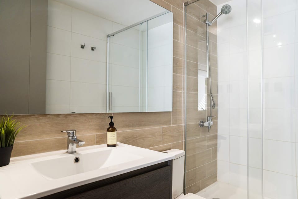 Indulge in the modern elegance of this stylish bathroom with a spacious shower and sleek fixtures.