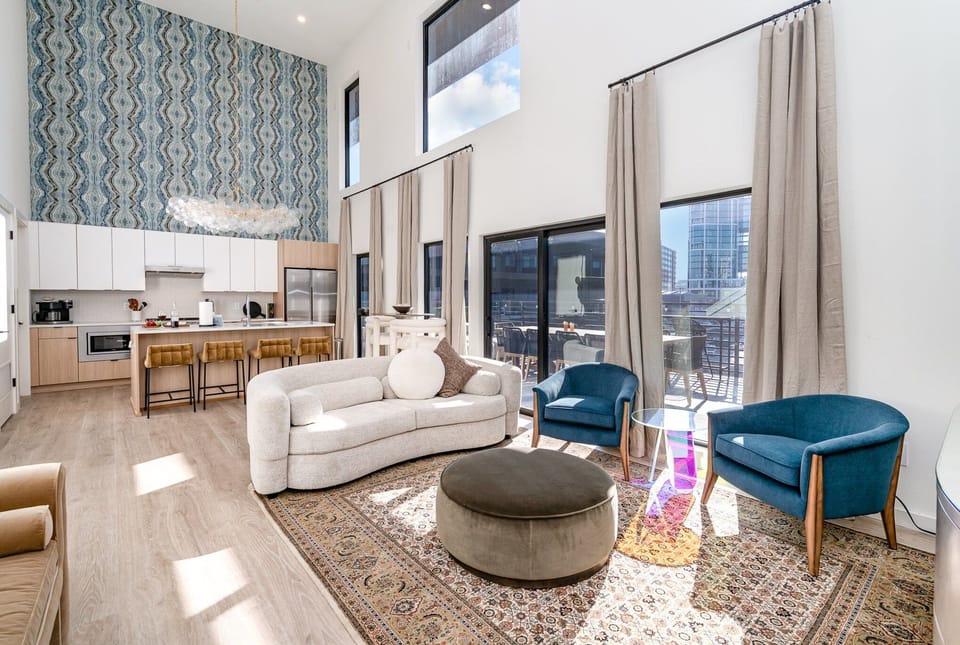 Soaring ceilings and designer touches define this open-concept living room, complete with a smart TV elegant lounge seating for ultimate relaxation.