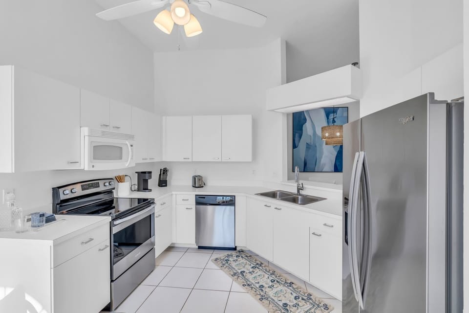 The kitchen of the coach home has tall ceilings and a pass through to the dining area 