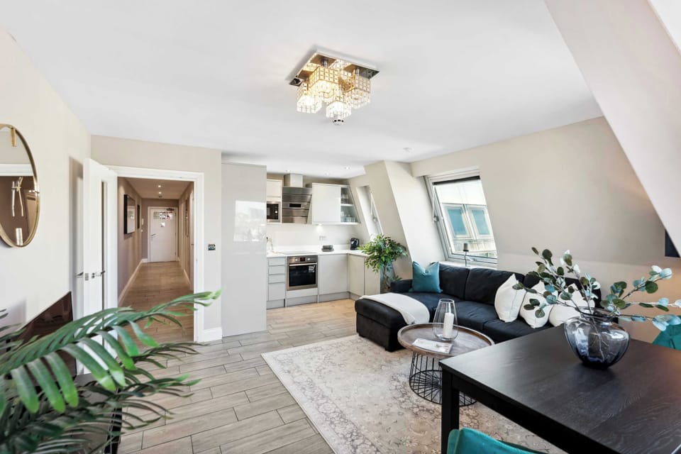 Sophisticated open-plan living with designer kitchen, plush lounge seating, and natural light streaming through loft-style windows Urban comfort meets Brighton elegance.