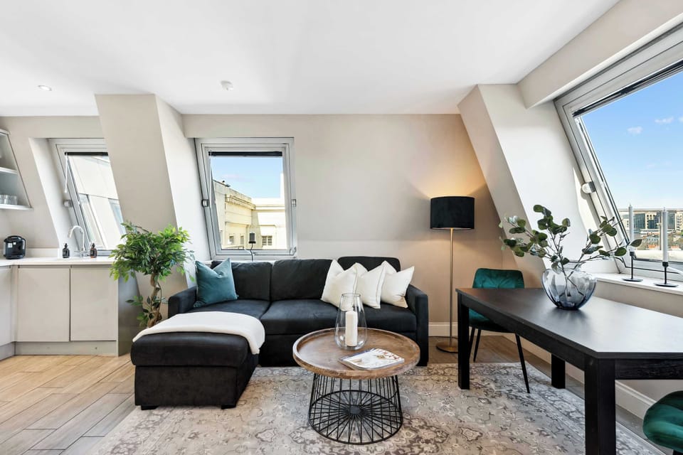 Inviting lounge with a comfy sectional, dining nook, and panoramic city views. Perfect for relaxing or working during your Brighton stay.