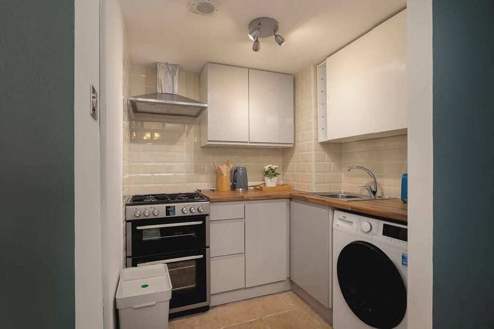 Modern kitchen with oven, washer and wooden counters 