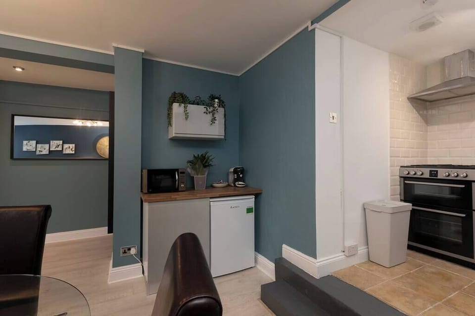 Compact kitchen with fridge, microwave, and coffee maker