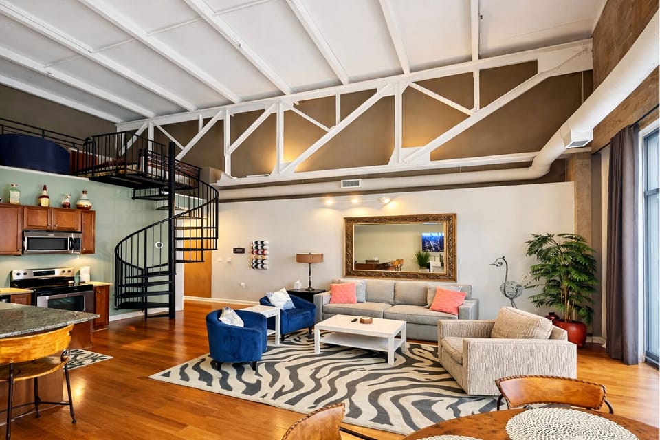 Coastal-Inspired Loft Retreat
A mix of industrial charm and coastal elegance, this open-concept loft features a fully equipped kitchen, cozy seating, and a stylish spiral staircase leading to a private loft