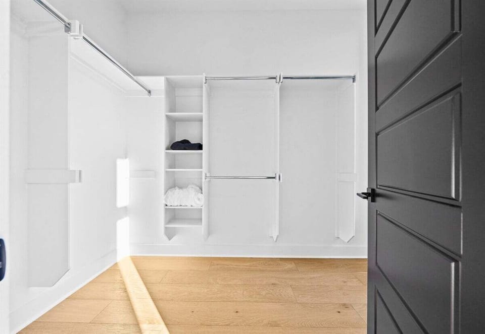 This spacious walk-in closet offers an organized and practical solution, complete with ample hanging space and shelving for all your essentials.
