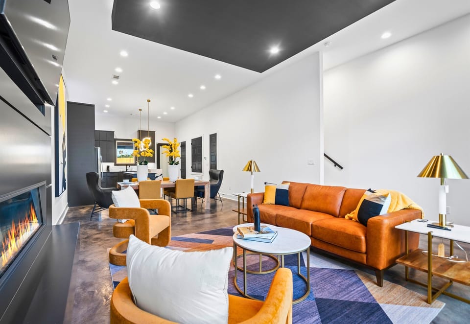 A beautifully designed living room with sleek furniture, a cozy fireplace, and bold accents, perfect for unwinding in style.