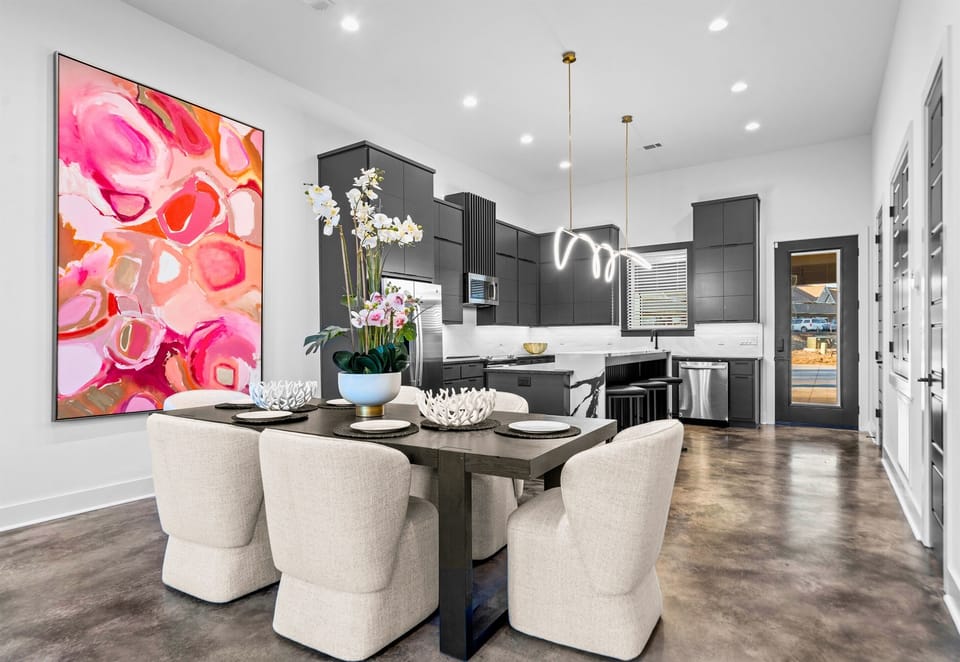 The dining area stands out with its bold artwork and clean, contemporary lines, offering a stylish and lively space for hosting family and friends.