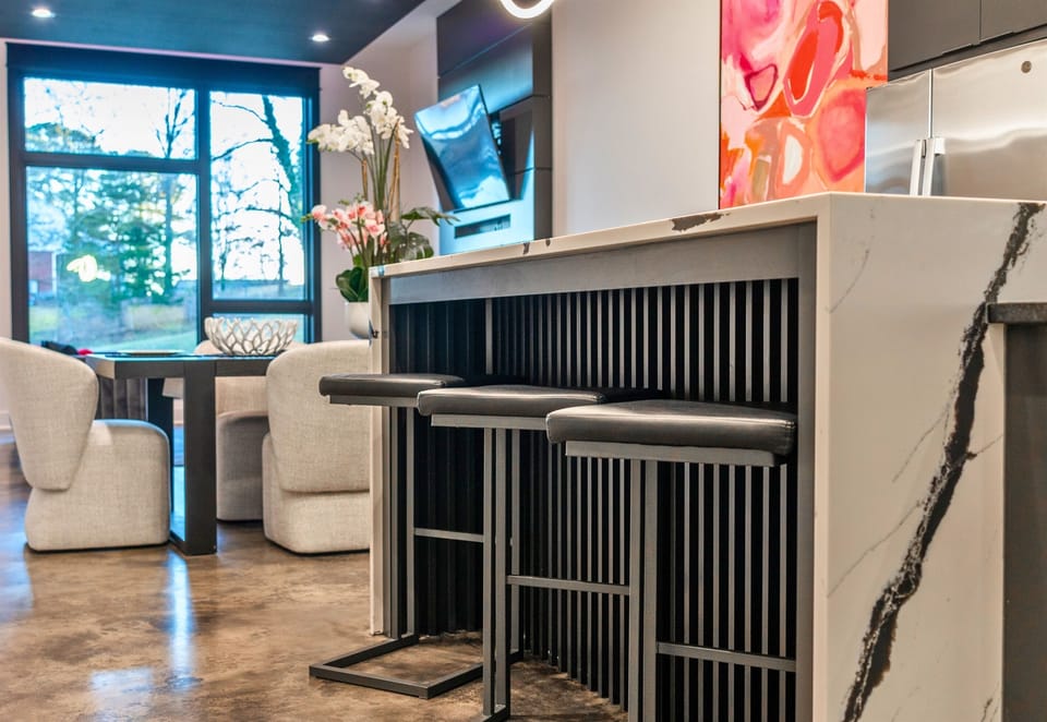 The stylish bar area offers comfortable seating, a polished island, and a seamless connection to the rest of the home, making it perfect for casual meals or morning coffee.