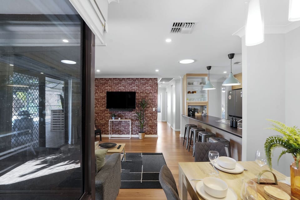 Open-plan kitchen, dining, and living area for easy entertaining with wine glasses