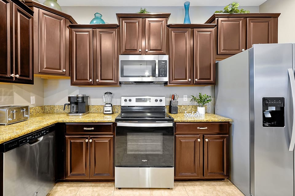 ully equipped kitchen featuring stainless steel appliances, including a microwave and full-size refrigerator.