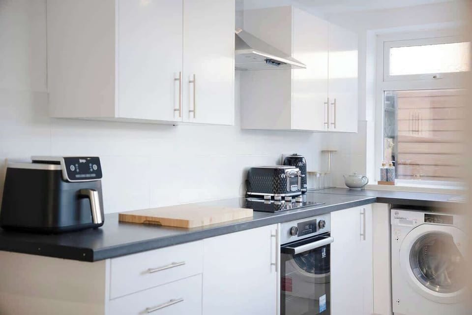 Kitchen equipped with all essentials, including a washer & dryer, oven, fridge and full cookware set.