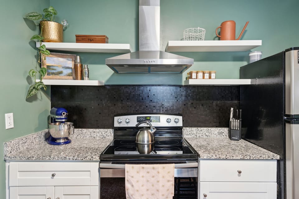 Fully equipped kitchen with updated appliances, open shelves, & small island