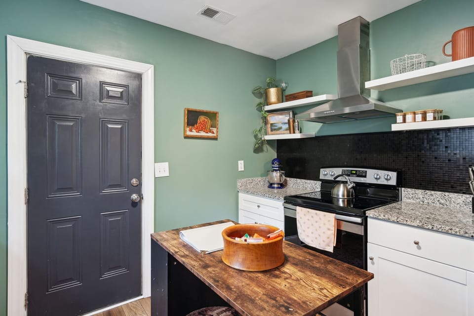 Fully equipped kitchen with updated appliances, open shelves, & small island