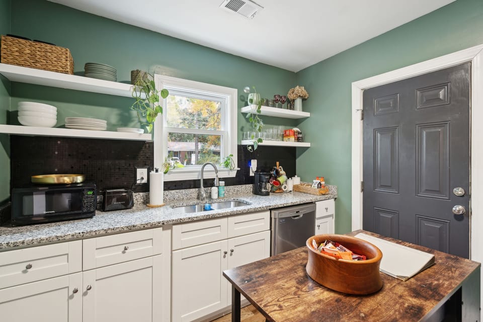 Fully equipped kitchen with updated appliances, open shelves, & small island