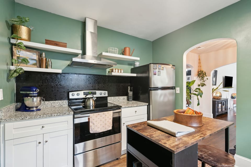 Fully equipped kitchen with updated appliances, open shelves, & small island
