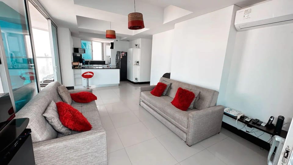 Sala de estar con balcón y vistas al mar.