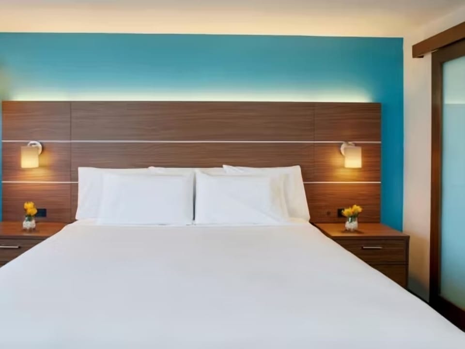 Drift off beneath warm bedside lights and a modern headboard.