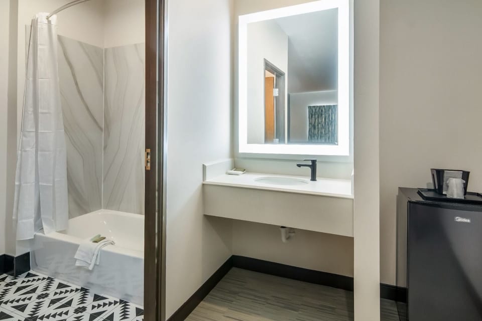 Start the day in a modern bath with bright backlit mirror.