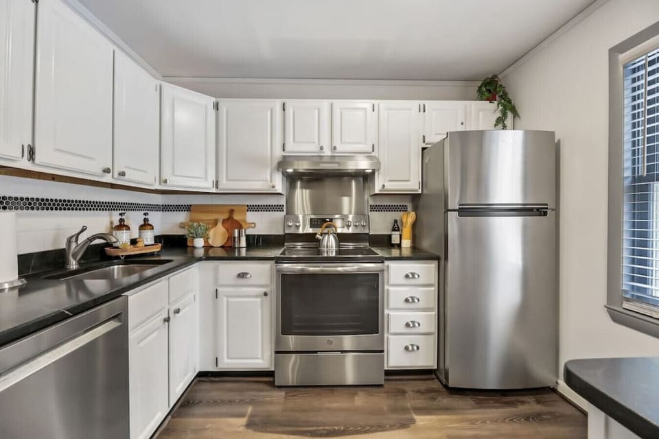 Stylish kitchen with fridge, oven dishwasher, plenty of counter space, and a cozy breakfast bar