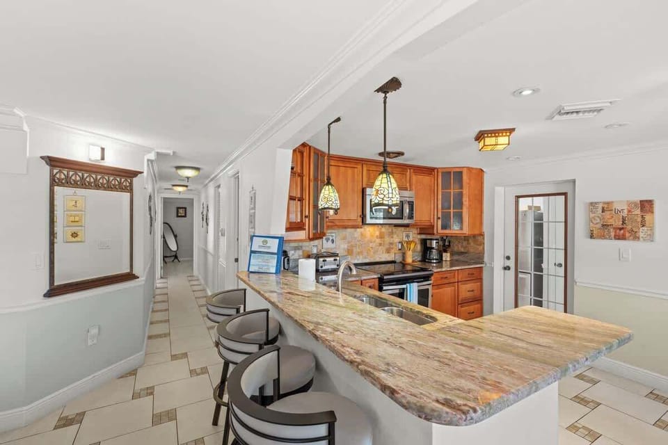 Prepare meals in style with the spacious L-shaped counter, offering plenty of room for cooking and entertaining #NaplesVacation