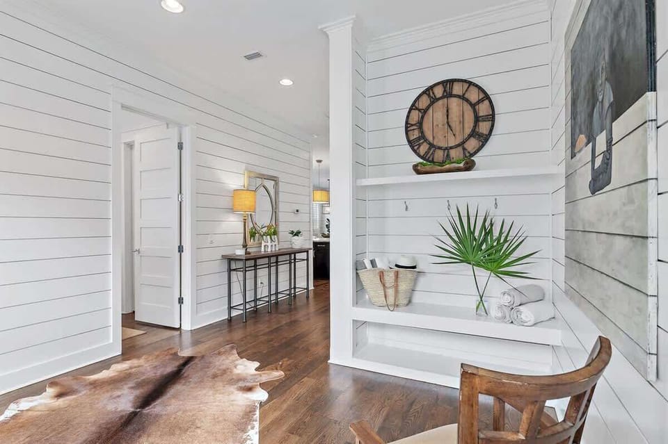 - Charming little corner has space to stash your things or simply sit and relax - Large rustic clock and palm leaves add personality to this breezy space - Whether you're coming or going, this spot greets you with warmth and ease 