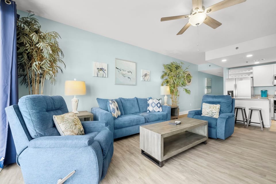 Relax in this modern living room with comfortable blue seating and natural light.