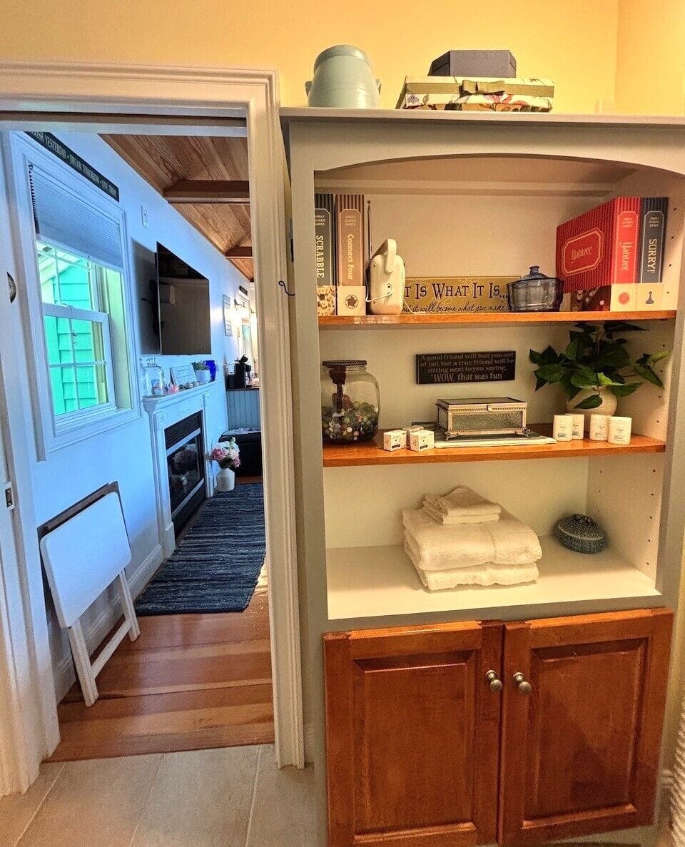 Step into the bright and airy bathroom where cozy cabinetry meets charming decor. Fresh towels await, books invite browsing, and every detail welcomes your arrival.
