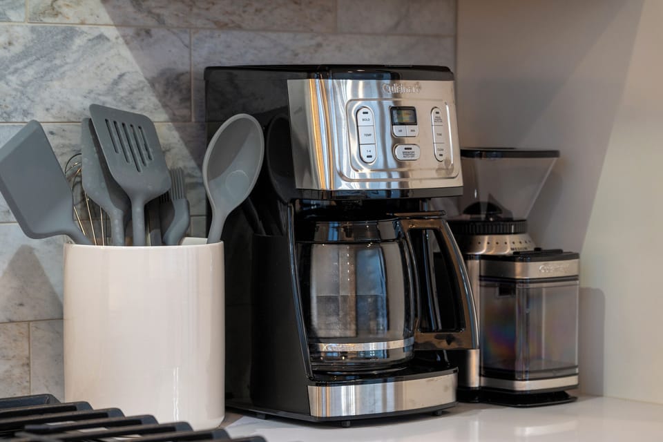 - Wake up to fresh coffee with this sleek programmable drip machine and grinder combo - Utensil holder and marble backsplash complete the upscale morning station - Conveniently placed near the stove for easy access during breakfast prep