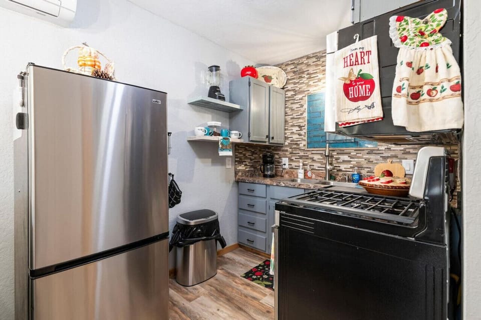 Full kitchen with refrigerator, stove and microwave.