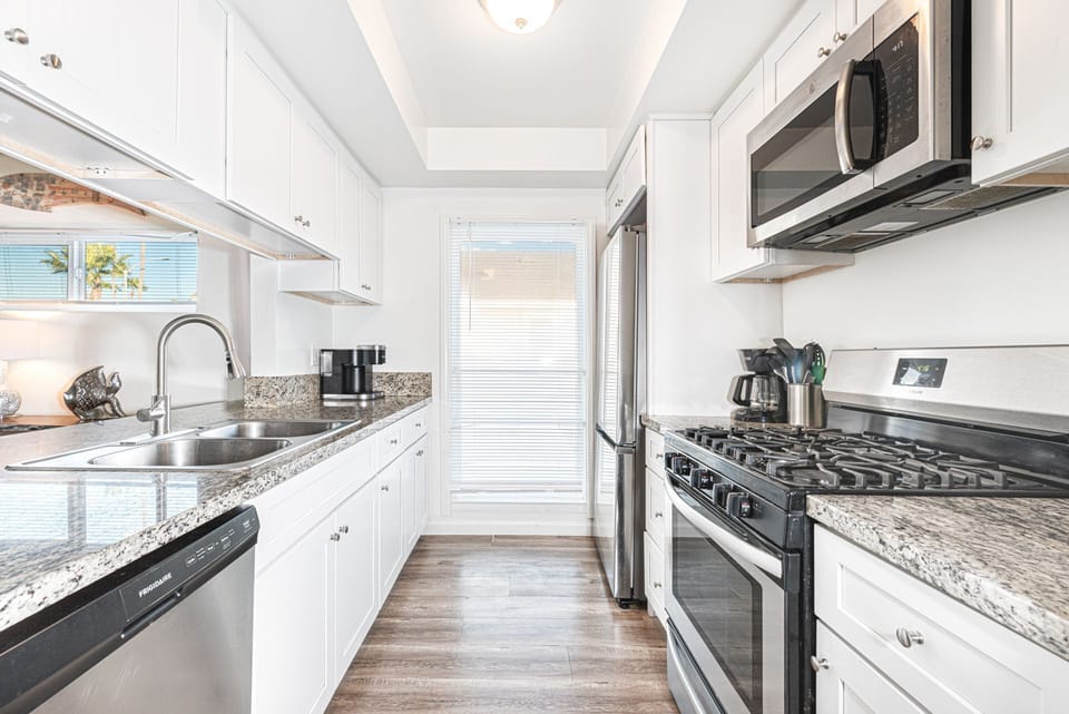 Sleek galley kitchen with plenty of countertop space and stainless steel appliances
                
