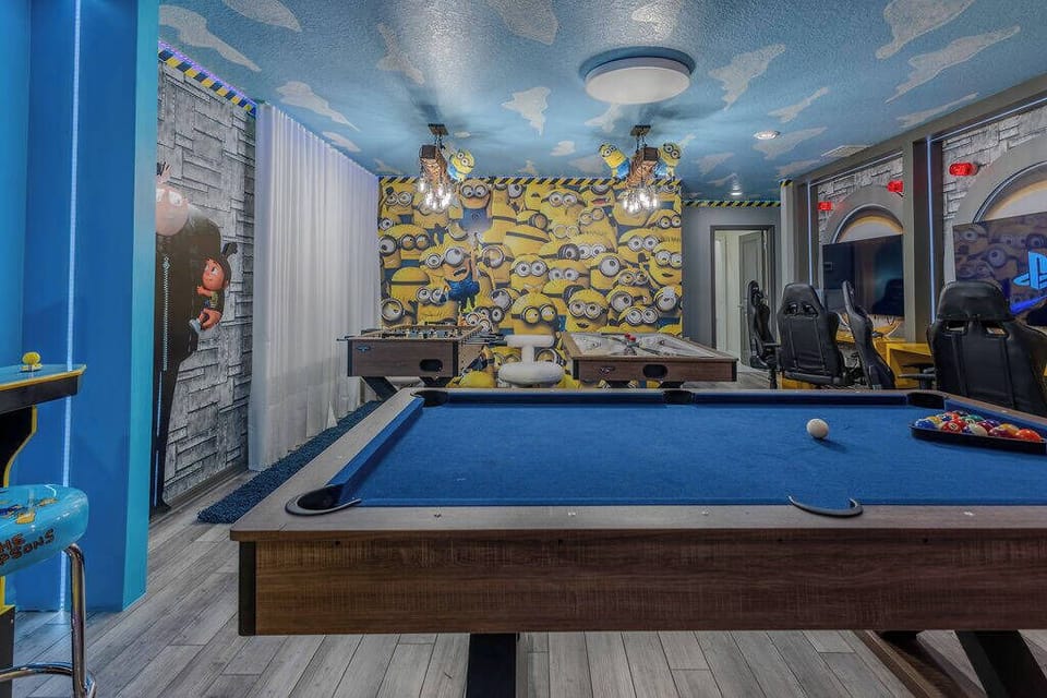 Discover a lively game room with a classic pool table dressed in deep blue felt, ideal for friendly matches. The colorful mural adds a fun vibe, and the unique ceiling lights provide a cozy atmosphere for your leisure time.
