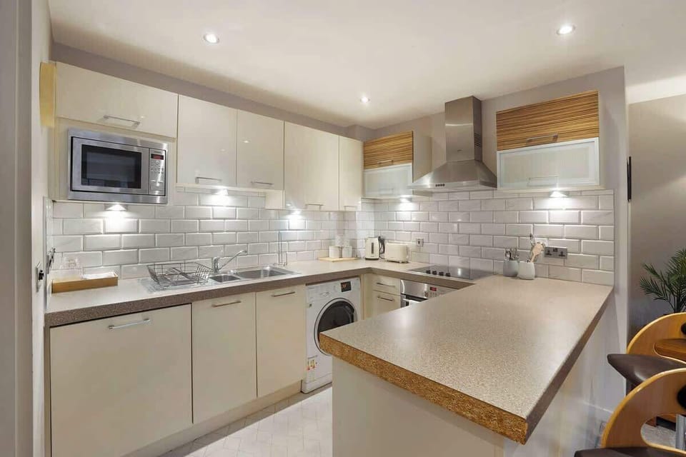 Kitchen equipped with all essentials, including a washer & dryer, oven, fridge and full cookware set.