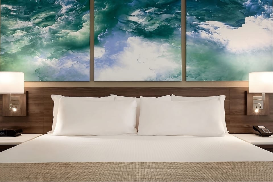 Sink into crisp linens beneath calming, ocean-inspired artwork.