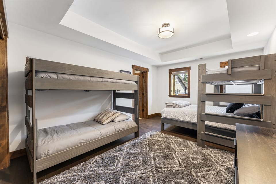 The bunk room is perfect for families or groups, featuring a twin-over-twin and a twin-over-queen bunk bed to comfortably accommodate guests of all ages. With its own en-suite bathroom, this space offers convenience and privacy.