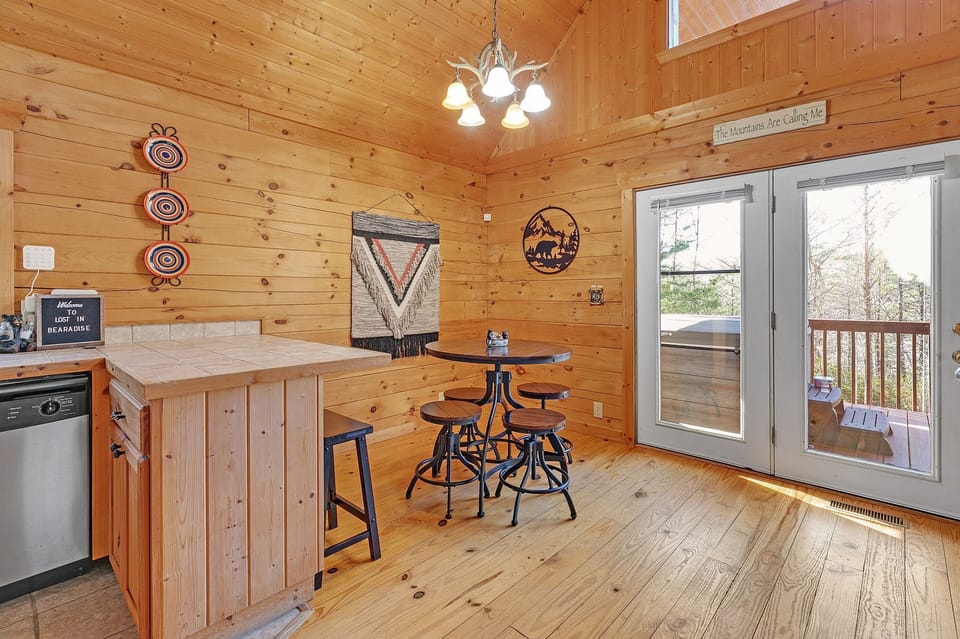 Dining space with a table and chairs for 4 and two additional stools at kitchen counter.