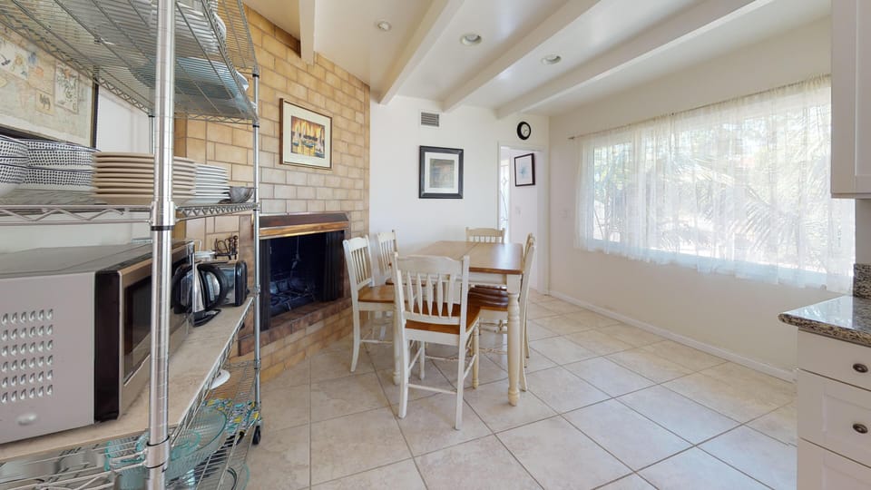 Open shelving and breakfast table in kitchen situated in front of the fireplace