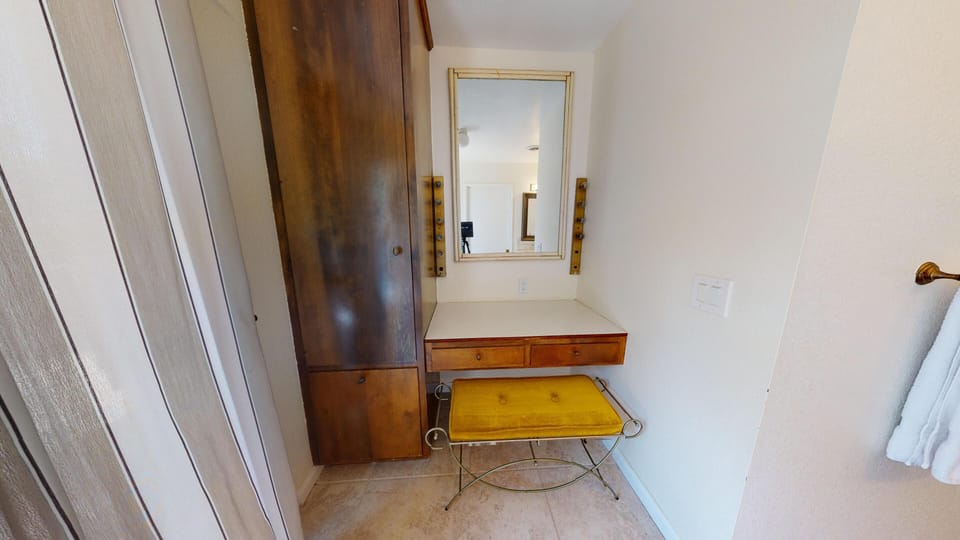 Built-in vanity in primary bathroom next to glass doors allow in natural light