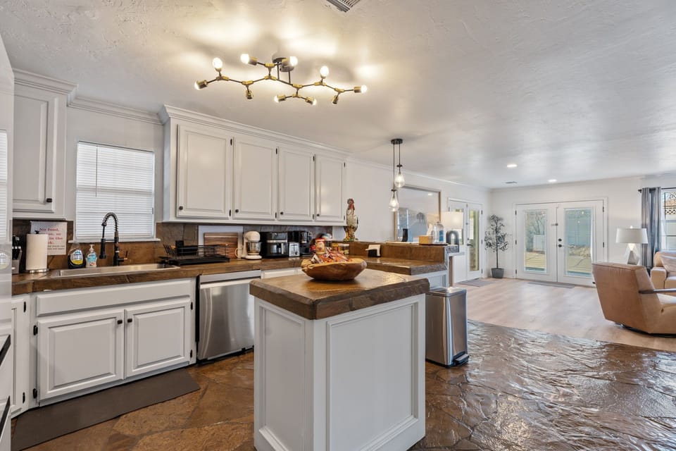Full kitchen  white cabinets with butcher block counters and updated appliances.