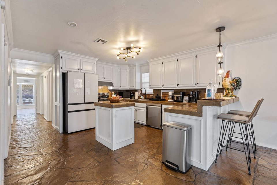 Modern kitchen with center island, bar seating, and pendant lights.
