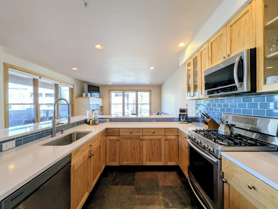 Your spacious kitchen features warm wood cabinets, granite counters, and modern appliances, creating the perfect space for cooking memorable meals together.