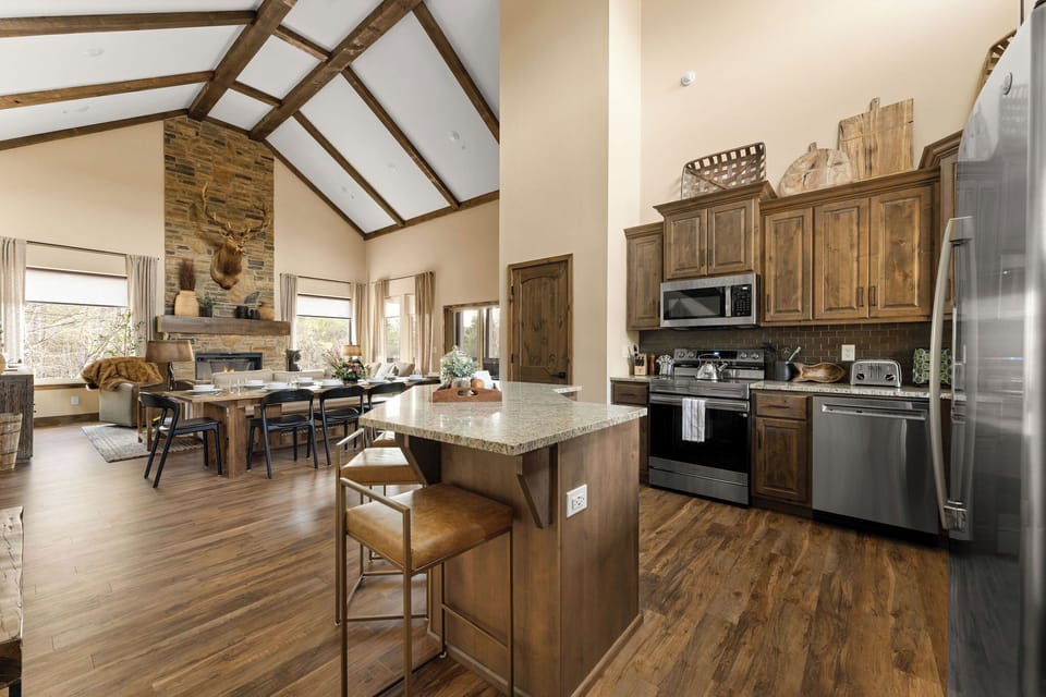 When you enter the front door, you'll step into the foyer and a well-stocked kitchen. Look beyond our spacious dining table, into the living room, and be greeted by our majestic "Roscoe" who proudly sits above the fireplace. 

The kitchen features granite countertops & stainless steel appliances! Cook, connect, and enjoy easy access to meals with a full-size fridge, microwave, ...