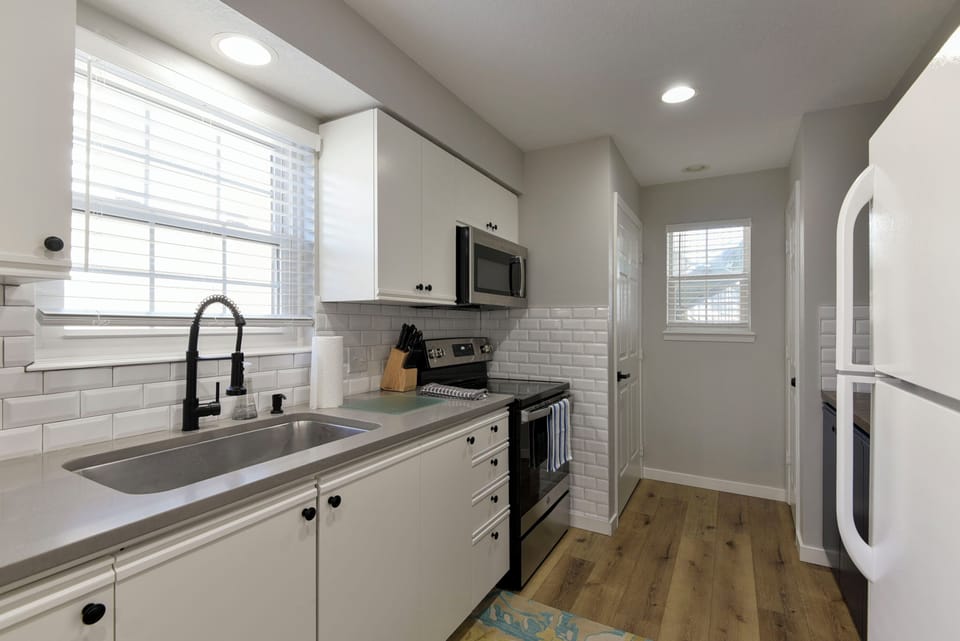 Kitchen with updated appliances, backsplash, fixtures, and more. Well stocked. 