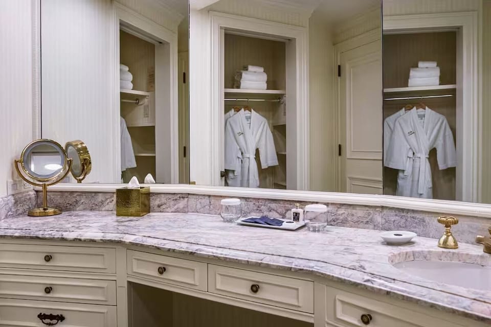 Refresh at the marble vanity with plush robes waiting nearby.