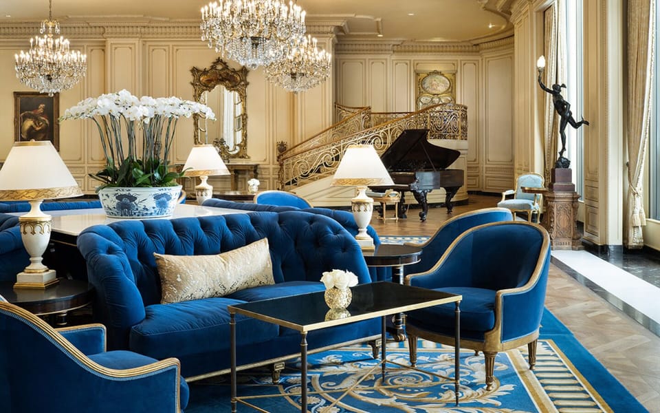Unwind beneath sparkling chandeliers in a grand, plush lounge.
