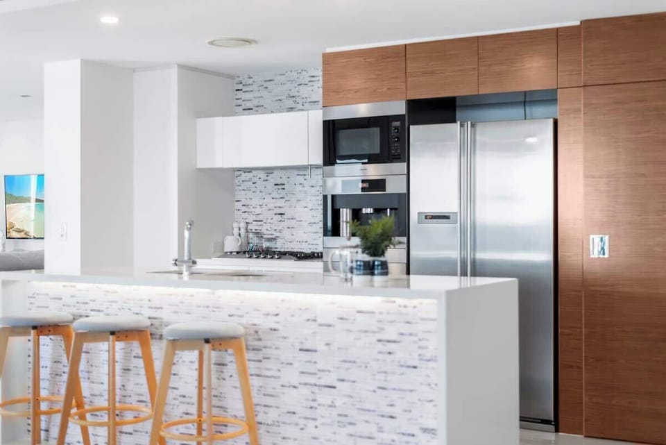 Modern, bright kitchen with European appliances and stone countertops.