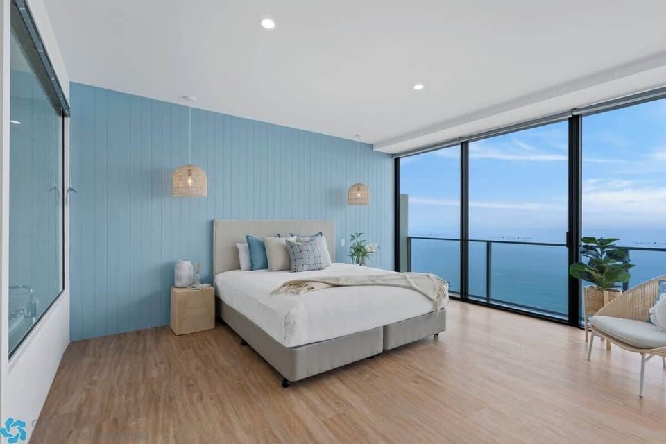 Master bedroom with a coastal style and stunning views of the ocean. 