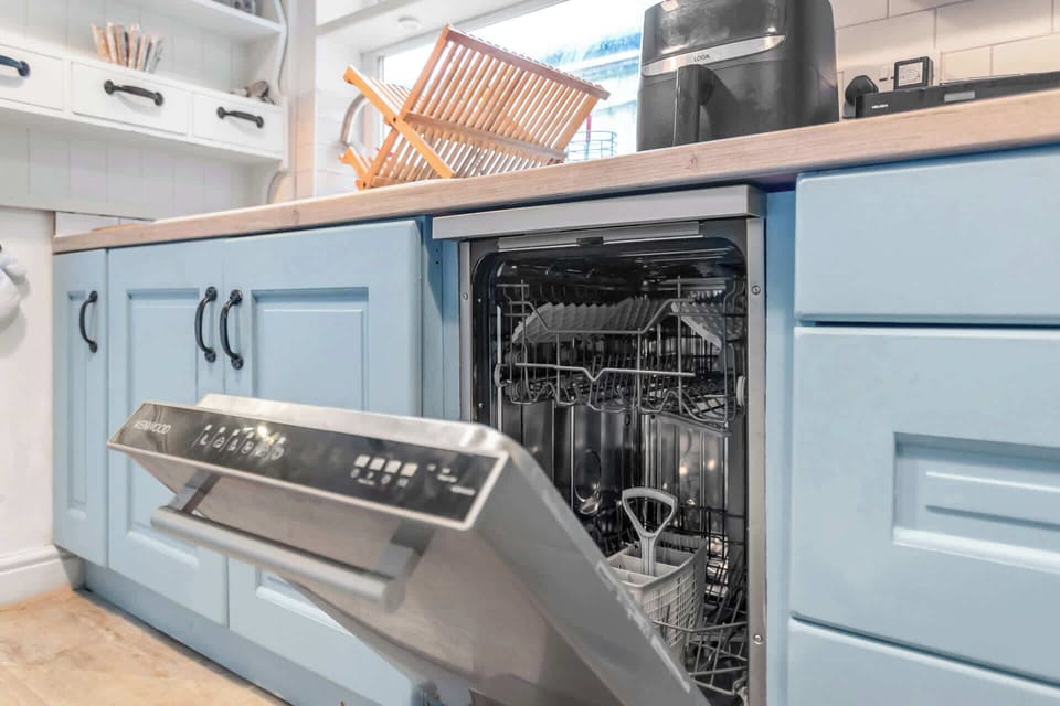 A modern kitchen with a sleek dishwasher and convenient under-sink storage.