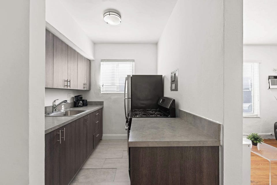 Modern kitchen with sleek cabinetry and stainless steel appliances, perfect for preparing meals in a cozy studio setting.